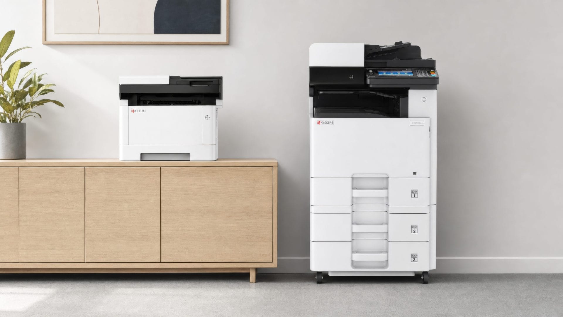 Kyocera A4 desktop printer on a sideboard beside a floor standing Kyocera A3 colour multifunction printer in a modern office