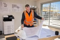 Leased Kyocera multifunction printer in a construction site office with A1 plans