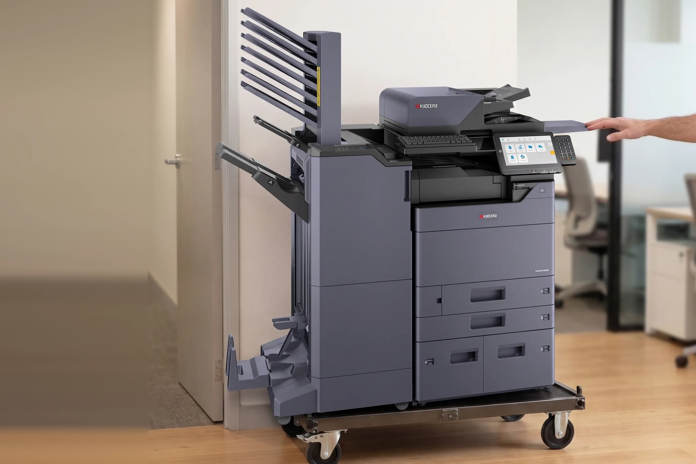 A Kyocera multifunction printer on a trolley at the door of an Australian office at the end of its rental term