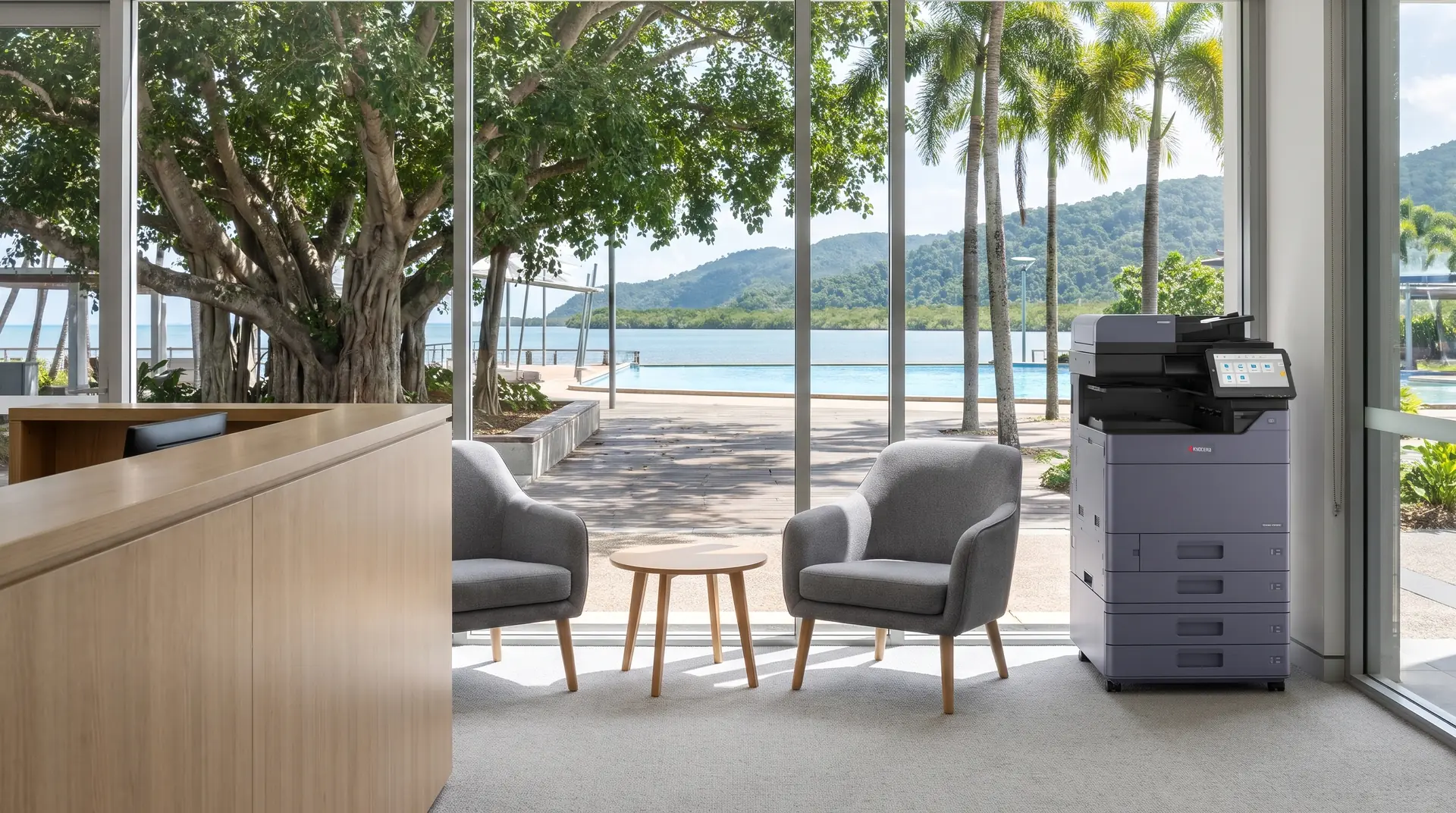 Kyocera photocopier on lease in a Cairns reception area overlooking the Esplanade boardwalk, fig trees and lagoon